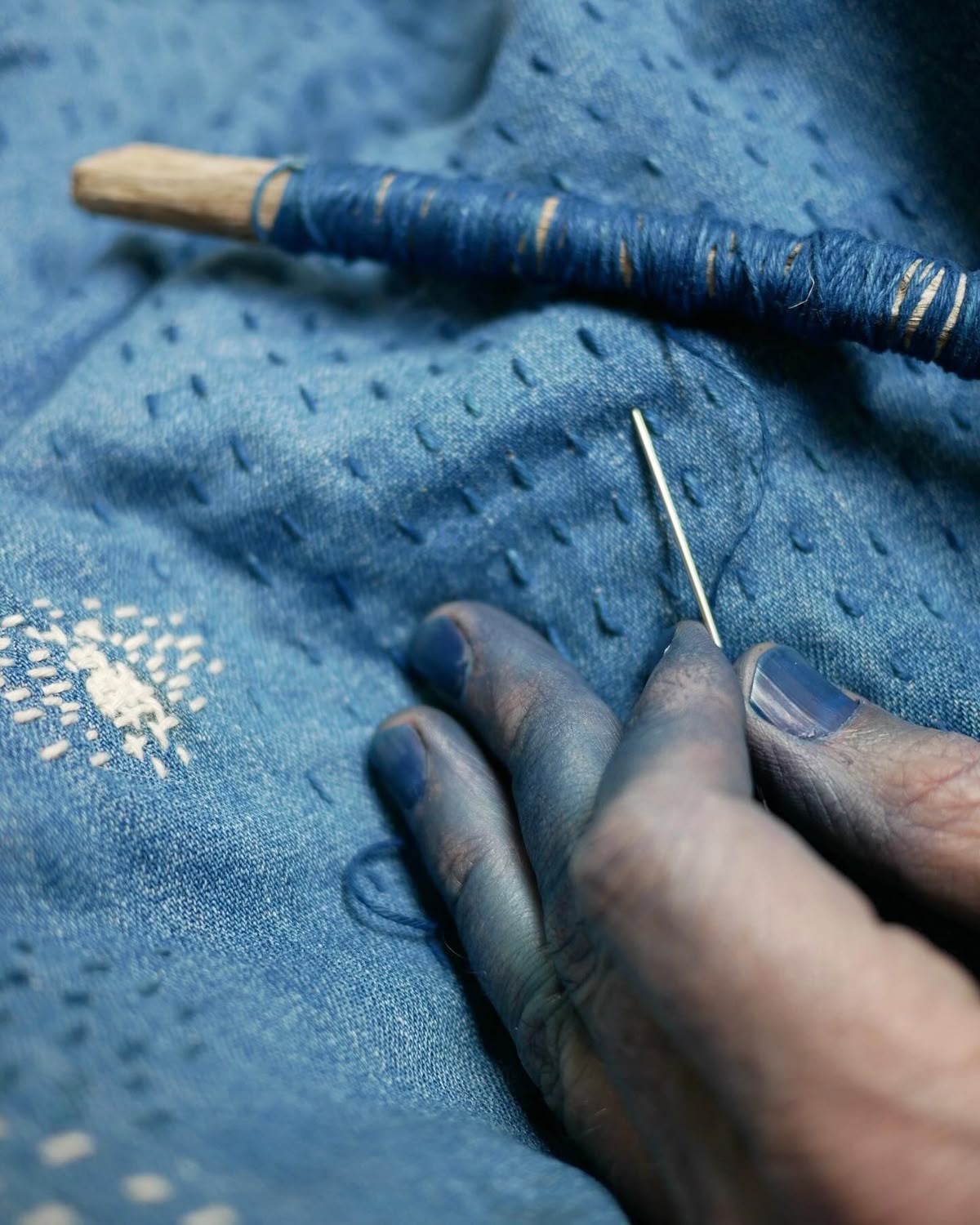 Hand stitching blue fabric